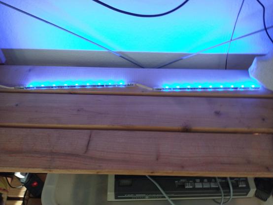 Two IKEA "Dioder" color LED strips in an empty IKEA shelf, turned to light blue color.