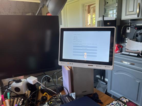 Seeed ReTerminal DM mounted hovering over messy desk