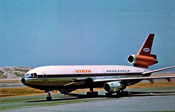 Under clear blue skies, the plane is taxing somewhere remote with rocky hils with dusty soil in the background.