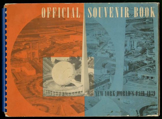 Photo of a book cover. The book is bound in a blue comb binding. The cover is red and blue with black and white photos of spaceage architecture overprinted. The title is “Official Souvenir Book” in large condensed type with “New York World’s Fair 1939” in small type.