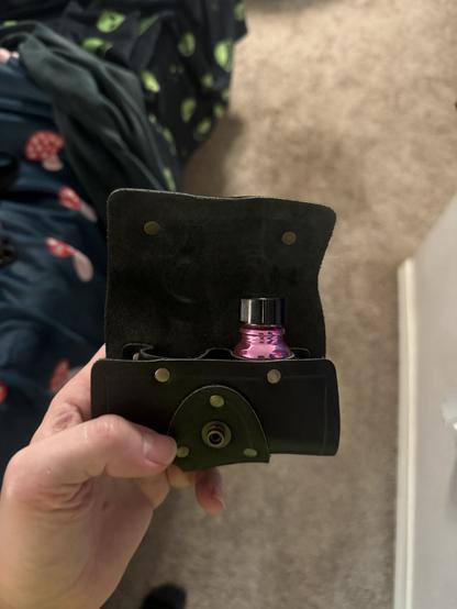 The leather alchemy pouch opened to reveal a bottle of poppers and a spot for a second bottle.