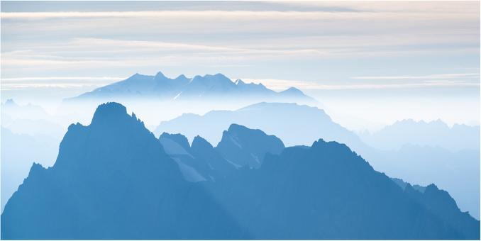Layers of jagged peaks receding into the distance in every paler hours of blue.