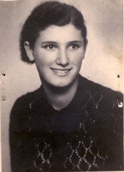 Vintage black and white portrait of a smiling woman with short hair, wearing a patterned sweater.