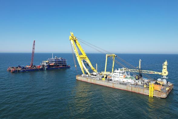 Luftaufnahme: Barge K10031 links und Schwimmkran HEBO LIFT 10 mit gelbem Kran rechts.