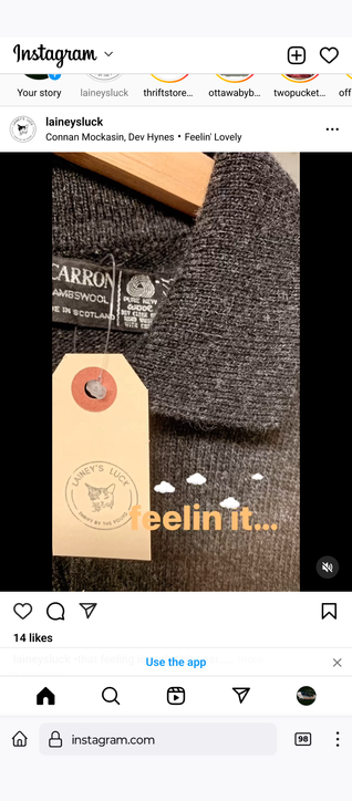 a georgeous charcoal grey sweater with the la el Carron lambswool made in scotland visible and a Lainey's luck tags hanging.  text overlay reads feelin it...