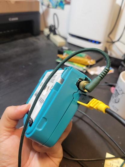A blue tape walkman without a cover for the cassette, and  a  1/4 inch to 35mm adapter and USB B cable in it