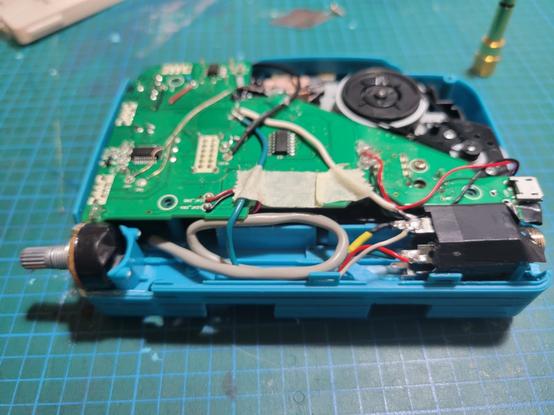The exposes circuit underside  of a tape walkman with a knib on the left and a 1/4 inch jack installed on wither side inside the battery well. A USB B jack still allows power to the walkman