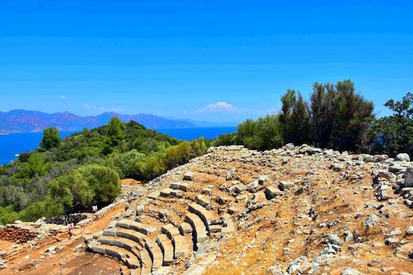 Remains of the ancient city of Amos.
Front — Remains of the abandoned theater.
Back — sea and mountains.

Ueberreste der antiken Stadt Amos.
Vorderseite – Ueberreste des verlassenen Theaters.
Rueckseite – Meer und Berge.