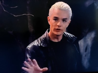 Spike in a black t-shirt and trench coat with his left hand out in a cave. From Buffy The Vampire Slayer Season 4, Episode 21