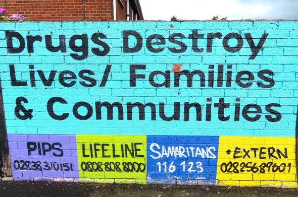 part of a wall-painting with "Drugs destroy lives/families & communities" and information about social services