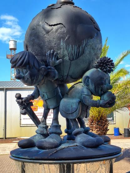 ein Brunnen in dem die Abrafaxe eine Weltkugel auf ihrem Rücken tragen