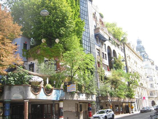 Hundertwasserhaus exterior, with cafe terrace and a lot of vegetation