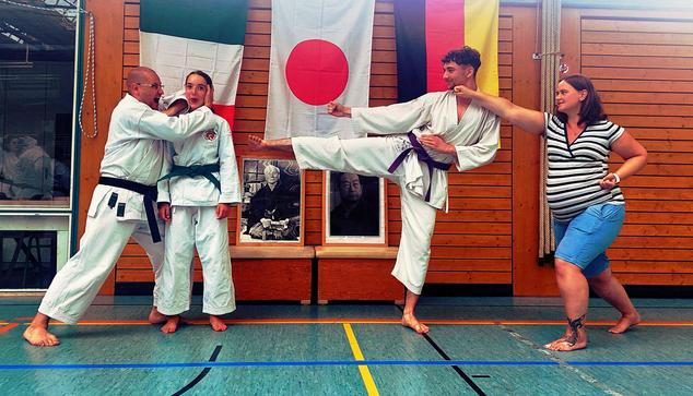 Spaßbild vor dem Shomen beim DJKB-Gasskuku 2024 in Baden-Baden

Vier Karateka, drei davon im Karate-Gi, stehen vor den Fahnen von Italien, Japan und Deutschland und den Bildern der beiden Großmeister Funakoshi Gichin und Nakayama Masatoshi und albern rum ;)