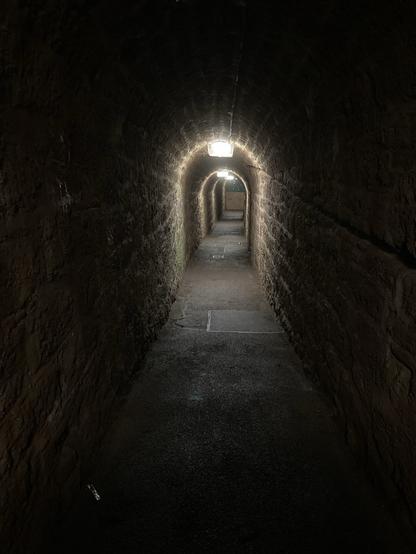 Stone arched tunnel. Dark but lit by permanent overhead light fixtures. Just like the ones the Famous Five used to find.