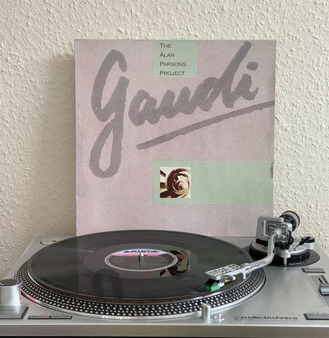 The cover sleeve of „Gaudi“ standing over a turntable playing the LP.