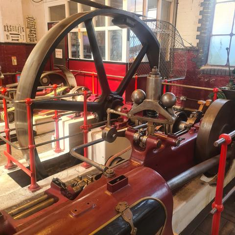 Large steam engine with cast iron flywheel