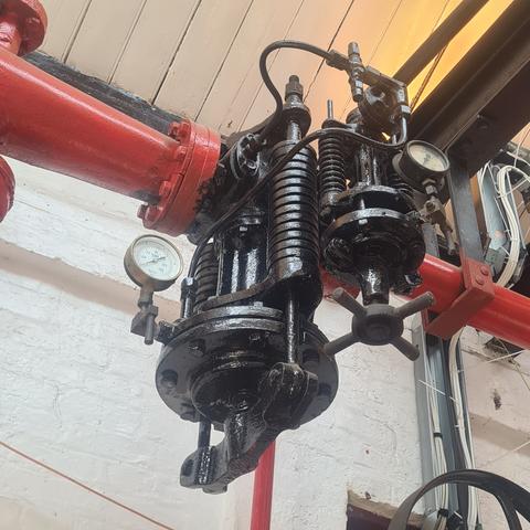 Some sort of contraption up in the rafters with various pipes and dials