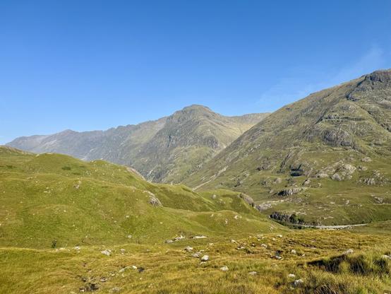 After a while a look back to where we had come from. The road through Glencoe almost invisible. More Munros set against the deep blue sky.