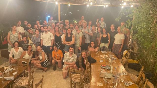 Participants and staff members (around 38 people) standing in a restaurant and looking very happy