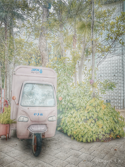 Small pink truck of Japanese shaved ice parked in front of the trees