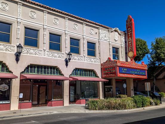 The Oroville State Theater - view of the exterior showing the marquee and neon sign. 

https://www.orovillestatetheatre.com/

Built between 1927 and 1928, the State Theatre was designed by San Francisco architect Timothy Pflueger and opened its doors on April 7, 1928. It was one of several movie palaces owned and operated by the T&D chain throughout California, a number of which Pflueger designed for the company. The State Theatre was Oroville’s first Spanish Colonial Revival style building, one of only two high examples of the style in the city.

This style of architecture is growing increasingly rare in California. It was originally popular in California and Florida, but with a massive influx of population and the resulting implications to development, many of the original buildings in California were torn down to make way for new construction. Most of the remaining examples are tucked away in smaller communities where development has occurred at a slower rate and older buildings were left mostly intact. The Oroville State Theatre is one such example, but it is also an example of how limited small town resources make restoration and preservation difficult. It is vital that these communities make every effort to save, salvage, and protect these remaining structures.