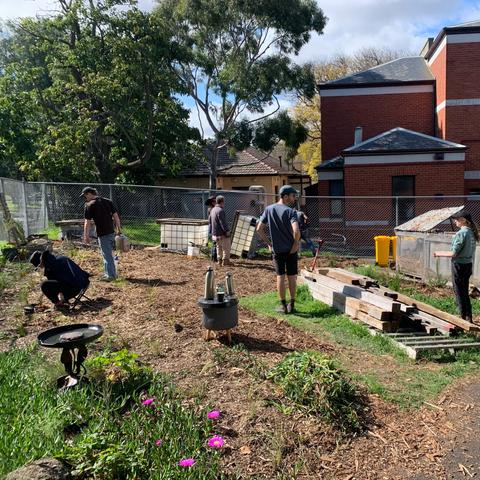 Volunteer gardeners planting an mulching behind Kensington Town Hall building