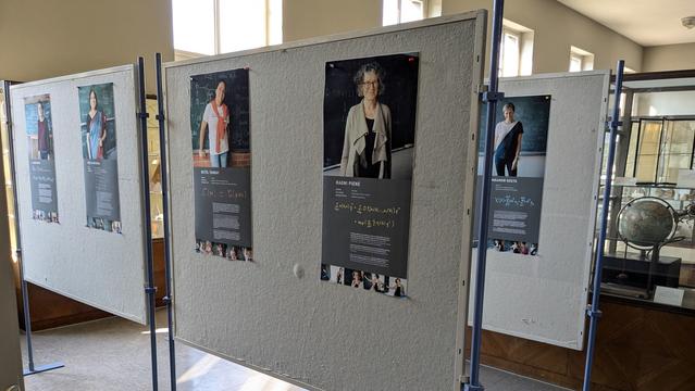 Stellwände mit Portraits , im Hintergrund ein Globus in einer der Vitrinen der mathematischen Sammlung