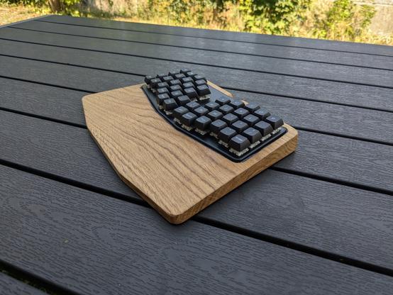 Atreus Keyboard sitting in an oak palm rest.