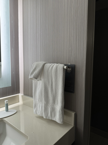 Hand towels hanging from a very low towel bar beside the vanity nearly touch the counter.