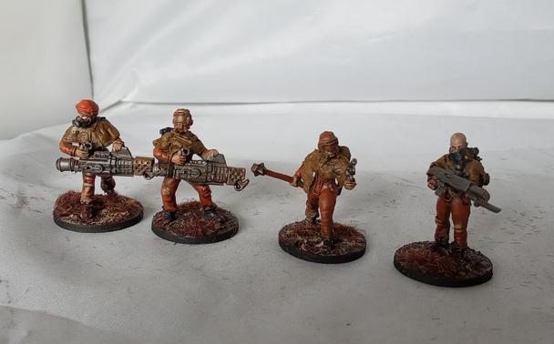 Four infantry models in orange jumpsuits, gasmasks and rags.
Left to right: flamer, flamer, sarge with mace and pistol, rifle.