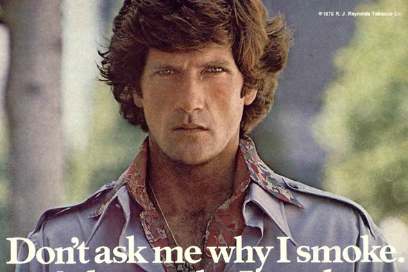 1976 Don't ask me why I smoke.

The image is a vintage photograph of a man with a mustache and shoulder-length hair, wearing a patterned shirt.
He has a serious expression on his face.
There is a text overlay on the image that reads "DON'T ASK ME WHY I SMOKE."
Tags: vintage, smoking, photography, portrait, 1976, August, mustache, shoulder-length hair, patterned shirt, serious expression