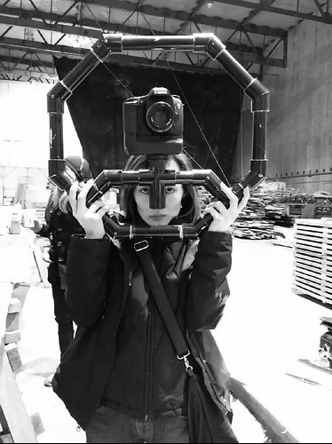 Photo of me holding up an octagon shaped DIY steadicam camera rig. Made with used black PVC pipe parts.