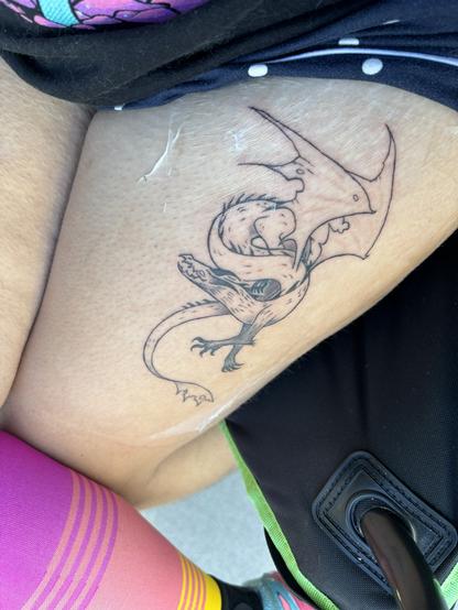 Photo of my spikey noodle dragon tattoo under second skin (a type of clear medical bandage/adhesive)