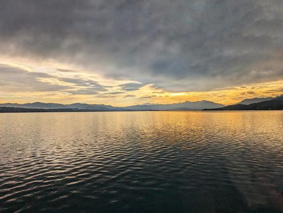 Blick über den großflächig orange schimmernden See.