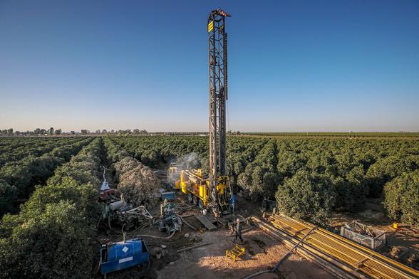 photo - drilling a groundwater well in an orchard
