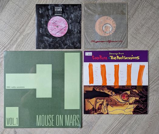 Pochette des quatre disques mentionnés dans le pouet, agencés sur le sol.