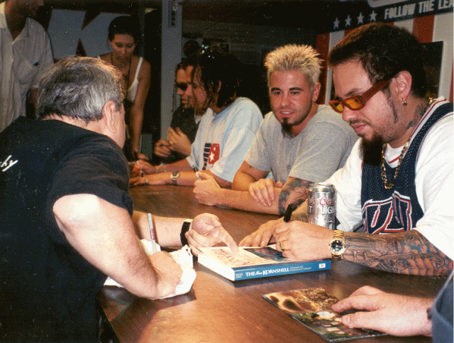 Korn(band) signing a copy of the book "The korn shell"
