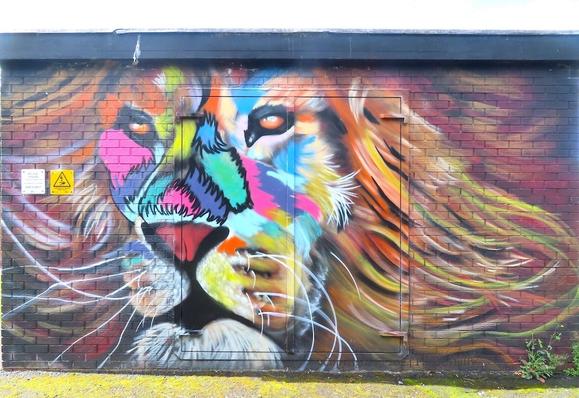 wall-painting of a colourful lion's face on an electrical sub-station