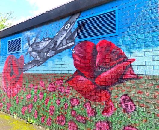 wall-painting on an electrical sub-station of a spitfire flying over a field of poppies