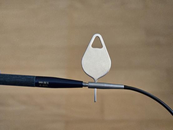 A sim card key inserted into the hole to tighten the top of an interchangeable circular knitting needle.