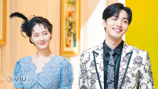 Park Gyu Young in a blue dress with a black hat with a feather and Kim Min Jae in a patterned suit from the 2021 South Korean drama "Dali and the Cocky Prince."