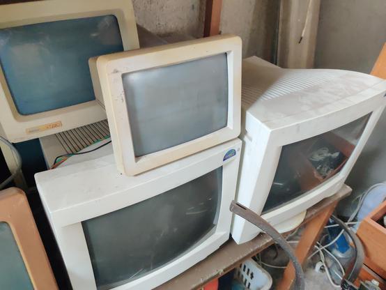 Four CRT monitors, probably all green-screen terminals. One of them is a DEC VT220 terminal.
