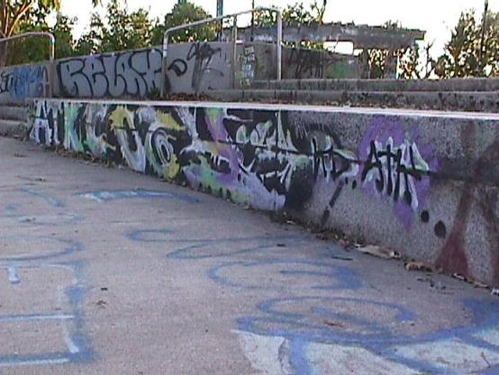 A Mavica picture of graffiti at a skate park reading "ATKCOGH"