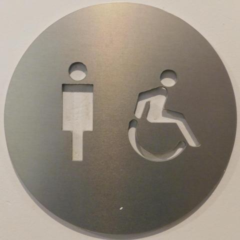 Washroom sign in a public place. It indicates males but with the shadow it is not clear.