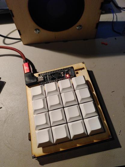 picture of a 4x4 macropad, white blank keycaps, wood plate