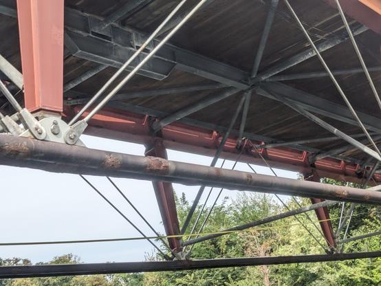 Runde Elemente von der Brücke mit einigen Roststellen mit mehr von der Brückenkonstruktion sichtbar