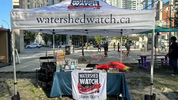 WatershedWatch.Ca
Event tent with website address on sides & logo on top.
Under tent is event table with nonprofit organization banner. Watershed Watch Salmon Society. The table is filled with information & leaflets.