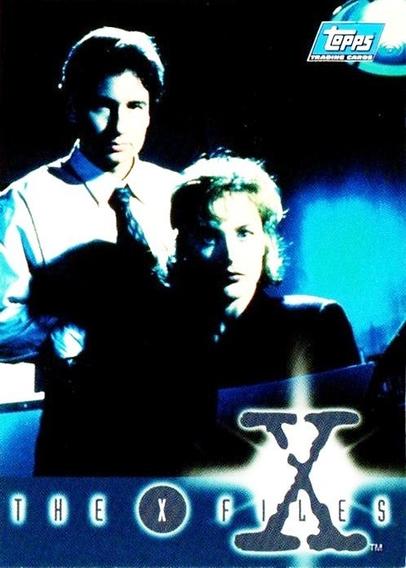 okay this is not the greatest card of all time, kind of dark and not too focused, but it is a very important one, because it is the first ever promo card for the cards which followed, or at least for series one, as issued by Topps. 
At the bottom there is a blue strip in which it has dark thin capital letters spelling out the X Files. Each letters is surrounded by white ovals with a kind of ghostly light blue aura.The exception is the X which is white and has a perfect dark blue circle, edged in light blue. Slightly off centre along that border is a big letter X in dark blue with a white cross beam of light behind it, and a big circle almost covering behind the letter X, which, as on screen, has a break in the top left hand diagonal line. 
Above this the picture is of the two leads,  dressed very businesslike, and I always think they look kind of serious, like they were not sure if they had done wrong in taking the parts. Of course, as we all know, they did great. And continue to do so. 
Just wish the picture was a tad brighter. However now I have put this card up, you may well see more.....