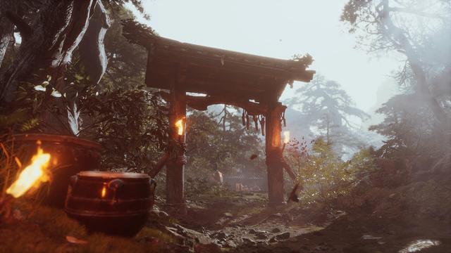 A misty forest scene featuring a wooden torii gate adorned with torches. In the foreground, there are dark pottery vessels, lush greenery, and a rocky path leading deeper into the woods. The atmosphere is tranquil and slightly ethereal.