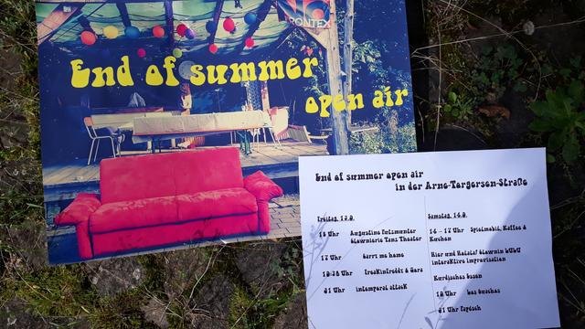 Eine Kleinkunst Bühne, vor der ein lila  Sofa steht. Darüber steht: End of Summer- Open Air